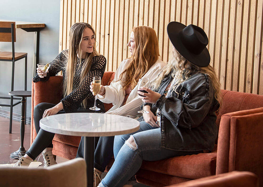 three women drinking wine in the lounge